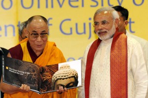 Tibetan spiritual leader The Dalai Lama (L) holds a souvenir as Narendra Modi looks on during the inauguration of the International Seminar on Buddhist Heritage in Vadodara, Gujarat on January 15, 2010.