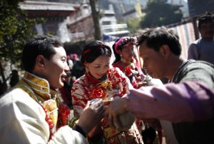 Erja, center, and Baima, left, celebrate with guests during their traditional Tibetan wedding near Danba, Sichuan Province Jan. 26, 2012. China has turned to promoting interracial marriage in an apparent attempt to assimilate Tibetans and stamp out rebellious impulses. (Carlos Barria / Reuters/REUTERS)