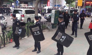[In this photo released by China's Xinhua News Agency, police officers stand guard near a blast site which has been cordoned off, in downtown Urumqi, capital of northwest China's Xinjiang Uygur Autonomous Region on Thursday. Attackers crashed a pair of vehicles and tossed explosives in an attack on Thursday near an open air market in the capital of China's volatile northwestern region of Xinjiang, leaving an unknown number of people dead and injured, state media reported. (AP Photo by Cao Zhiheng)]