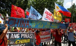 Demonstrators display a part of a fishing boat with anti-China protest signs during a rally by different activist groups over the South China Sea disputes, outside the Chinese Consulate in Makati City, Metro Manila, Philippines July 12, 2016. REUTERS/ERIK DE CASTRBY