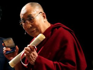 Tibet's exiled spiritual leader the Dalai Lama poses after receiving honorary citizenship of the city of Milan at the Arcimboldi theater in Milan - Reuters.