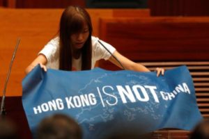 Newly elected lawmaker Yau Wai-ching displays a banner before taking oath at the Legislative Council in Hong Kong, China October 12, 2016. REUTERS/Bobby Yip