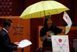 Re-elected lawmaker Leung Kwok-hung holds an umbrella while taking oath at the Legislative Council in Hong Kong, China October 12, 2016. REUTERS/Bobby Yip